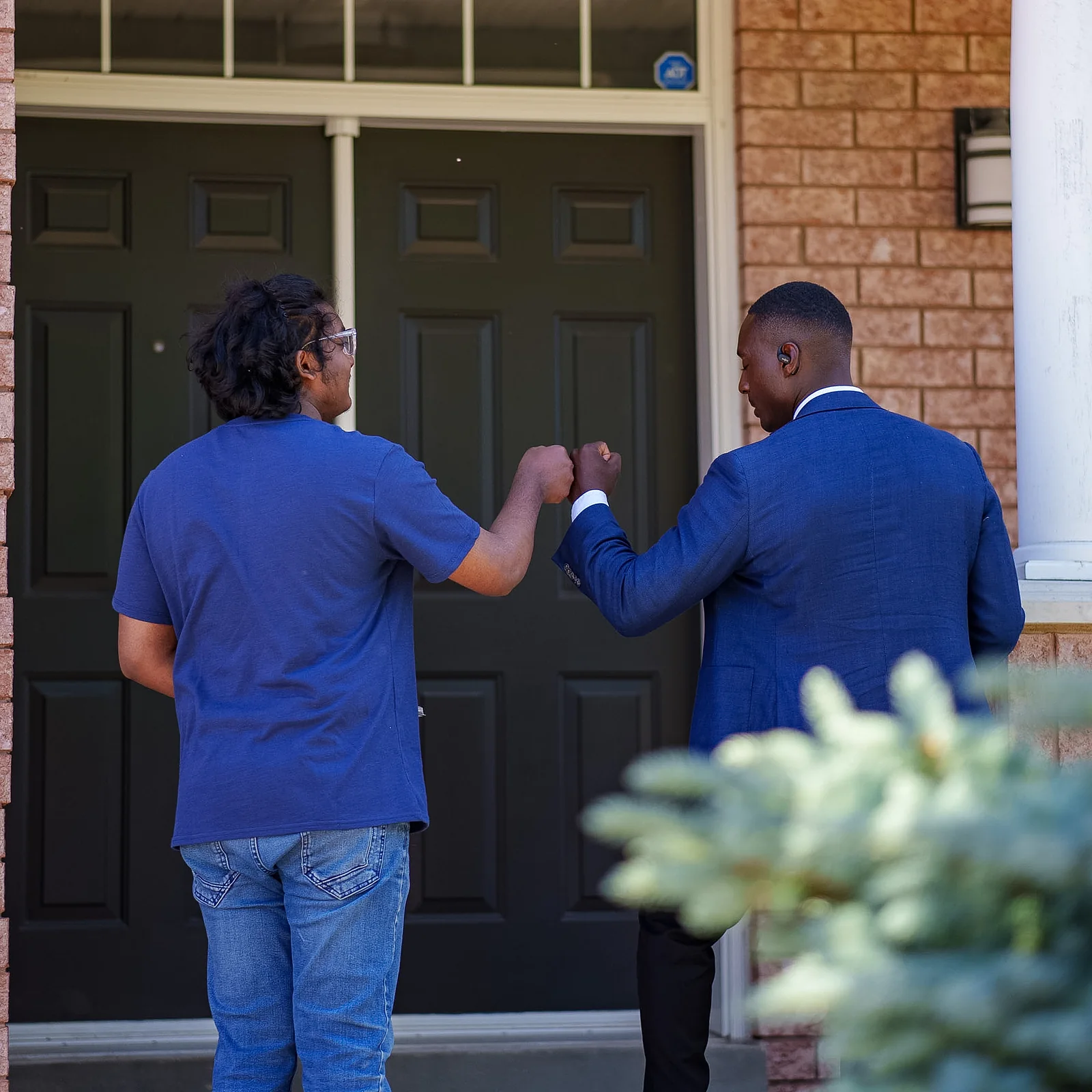 Jay Hayles greeting a resident with a fist bump on their doorstep