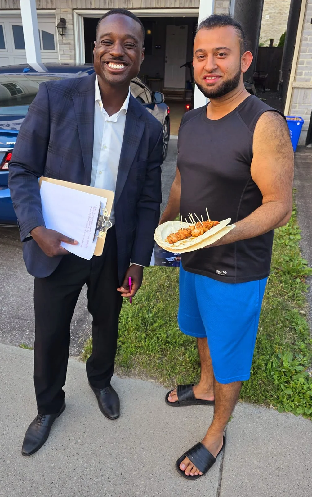Jay Hayles talking with a resident at a neighbourhood barbecue