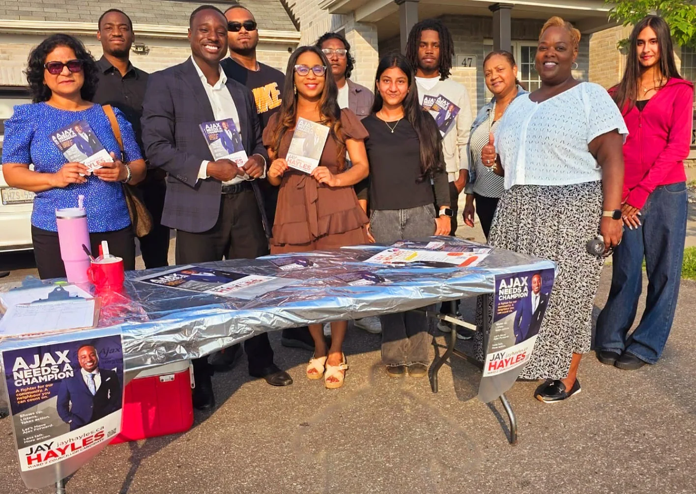 Jay Hayles and volunteers meeting residents at an outdoor campaign table
