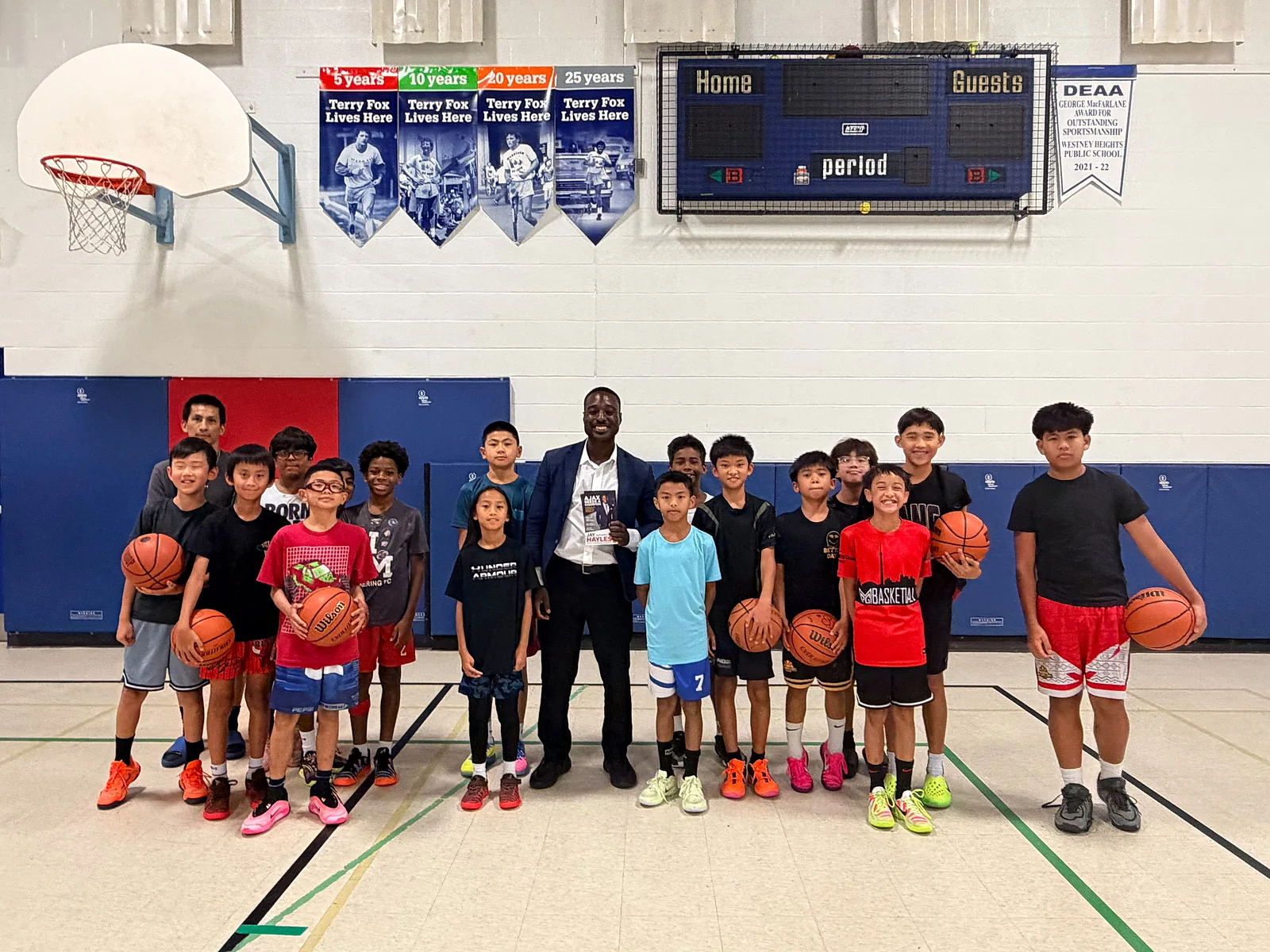 Jay Hayles with a youth basketball team in a school gymnasium